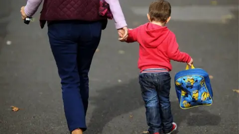 PA Woman and child walking to nursery