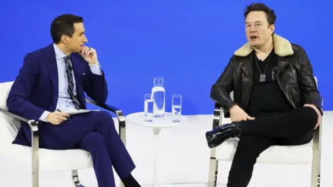 Getty Images Columnist Andrew Ross Sorkin and Elon Musk speak during the New York Times annual DealBook summit