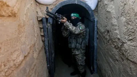 Getty Images A fighter from Hamas's military wing, the Izzedine al-Qassam Brigades, stands in front of a tunnel in the Maghazi camp, in central Gaza (19 Jul 2023)