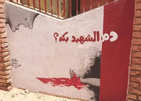 BBC A mural showing a person crying over a bleeding hand with the words: "What is martyrs' blood worth?" - Khartoum, Sudan