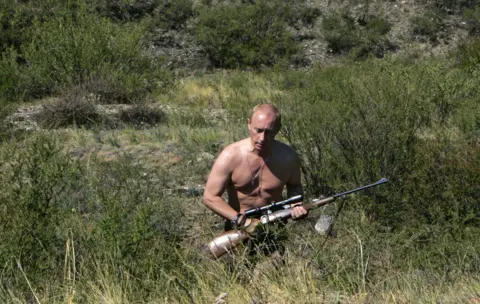 AFP Russian President Vladimir Putin carrying a hunting rifle in the Republic of Tuva, 15 August 2007.