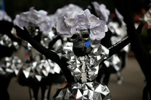 Reuters A participant wearing a skull mask performs during the annual Day of the Dead parade in Mexico City