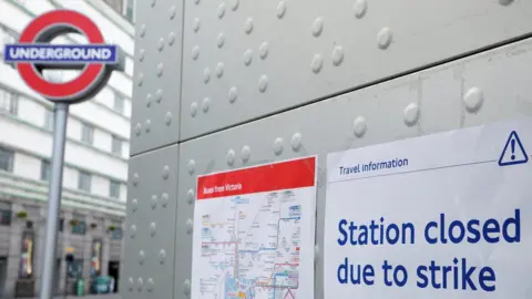 Reuters File image showing a tube roundel next to signs warning of station closures.