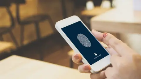 Getty Images Finger over thumbprint scanner on phone