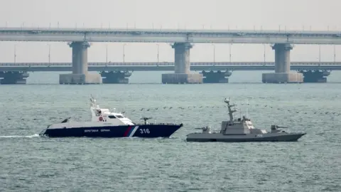 Reuters A seized Ukrainian ship is towed by a Russian Coast Guard vessel out of the port in Kerch, near the bridge connecting the Russian mainland with the Crimean Peninsula, 17 November 2019