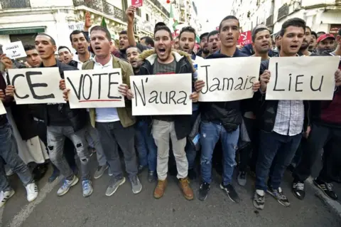 AFP Algerian demonstrators on 6 December carry placards that read in French: "This vote will never happen".