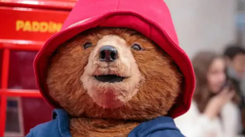 Getty Images Paddington Bear wearing a blue duffle coat and a red hat in front of a British red phonebox.