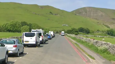 Google Double red lines on a road with a hill behind the road