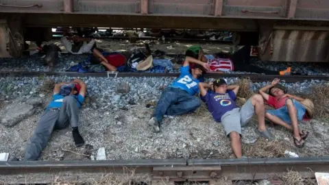 AFP/Getty Images Migrants from the caravan rest on rail tracks in Arriaga, Mexico. Photo: 26 October 2018