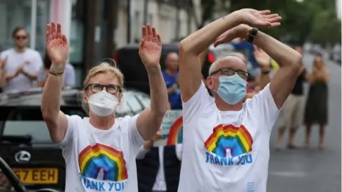 Reuters People applauding NHS workers in London