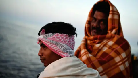 AFP Bangladeshi migrants look at the sunrise onboard a Mediterranean rescue ship - May 2018