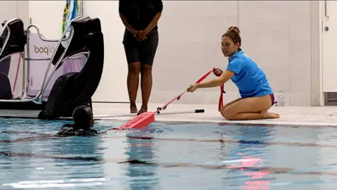 Seren Jones Seren Jones helping a swimmer in a pool