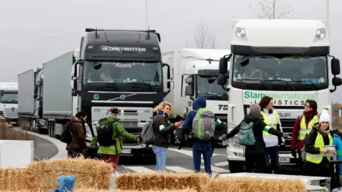 Getty Images Activists formed a human chain, lay on hay bales and dumped old fridges and microwaves outside Amazon depot