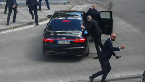 Security officers bundle prime minister into car