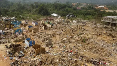 Reuters A view shows debris of houses and other buildings that were destroyed when a vehicle carrying mining explosives detonated along a road in Apiate, Ghana, January 21, 2022