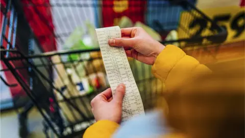 Getty Images Shopper looks at bill