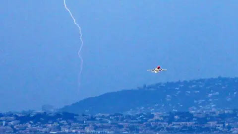 Getty Images A plane takes off from Nice airport in France as lightning strikes, 5 June 2011