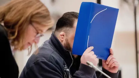 AFP/Getty Former nurse Niels Hoegel, accused of killing more than 100 patients in his care, arrives with his lawyer Ulrike Baumann, in the courtroom on 30 October 2018