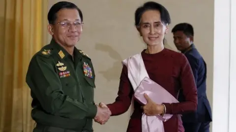 Reuters Gen Min Aung Hlaing and Aung San Suu Kyi shake hands