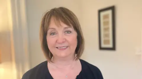 Margie button. He has short brown hair with a fringe, wearing a black top and necklace. She is smiling at the camera.