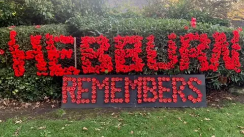 Mark William Young Hebburn Remembers sign made out of knitted red poppies