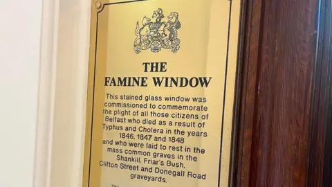 A golden ridge that says the famine window. There is bellfast board crest on the top.