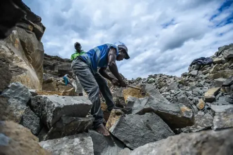 Gerald Anderson/ Getty Images Man cutting large rocks - 03 June.