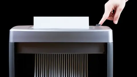 Getty Images A man shredding paper