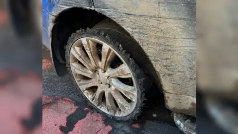 Image of the vehicle's rear wheel, which is missing a tyre.