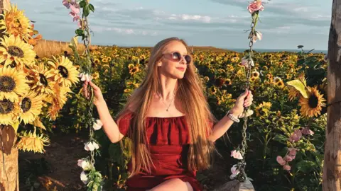 Stacey on a swing made of sunflowers