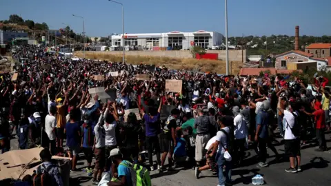 Reuters Refugees and migrants from the destroyed Moria camp protest after the news about the creation of a new temporary camp on the island of Lesbos, Greece, 11 September 2020