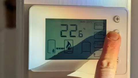 Getty Images Finger turning down thermostat