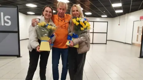 Dawid Wojtowicz/BBC Robert Chesnaye with his wife and step daughter at Luton Airport