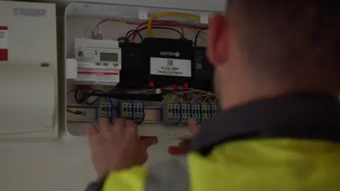 A man looking at a fuse box