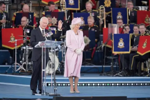 Andrew Matthews/PA Media King Charles and Queen Camilla on stage 