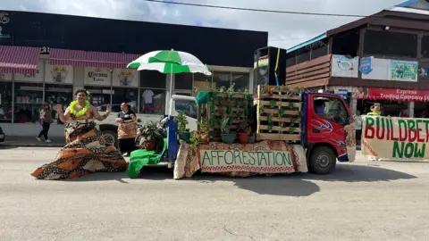 Sign showing forestation and building improvements in Tonga