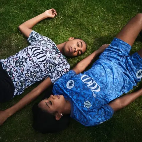 Jake Green models in the shirt on a football pitch
