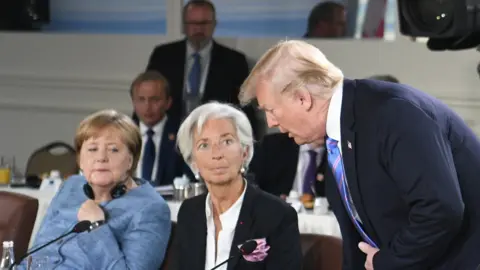 President Trump, with Angela Merkel and Christine Lagarde at the G7 summit in Canada