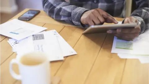 Getty Images Man paying bills