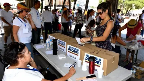 AFP A Venezuelan resident in Madrid votes at a polling station during a symbolic plebiscite on president Maduro"s project of a future constituent assembly, called by the Venezuelan opposition and held at the Plaza Colon in Madrid on July 16, 2017