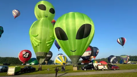 BRISTOL INTERNATIONAL BALLOON FIESTA Astro the Alien and another alien balloon are inflated at a previous balloon fiesta