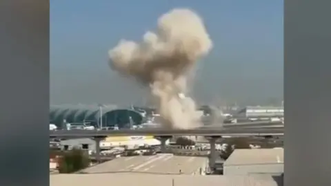 Smoke billows close to Dubai International Airport following a strike