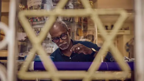 Dinesh Madhavan Thaha stitches a kippah in his shop