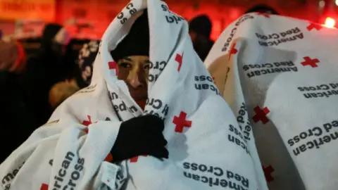 Reuters Evacuees wear blankets as they stand after a fire at an apartment building in Bronx, New York, U.S., December 28, 2017.