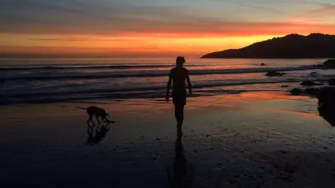 Josh Pike Josh on the beach with his dog at sunrise