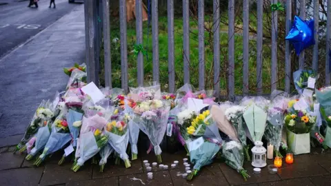 Ben Birchall/PA Floral tributes to Max Dixon and Mason Rist on Ilminster Avenue in Knowle West