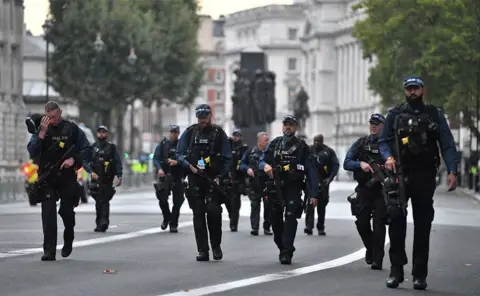 EPA Armed police officers patrol the streets ahead of the procession to carry the body of Britain's late Queen Elizabeth II from Buckingham Palace to Westminster Hall, London,14 September 2022