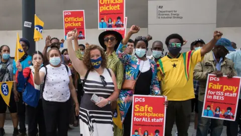 Getty Images PCS members on a picket line during a strike in July 2021