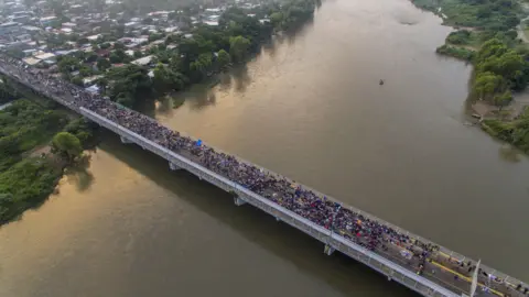 Getty Images The migrant caravan crosses from Guatemala into Mexico, in October 2018