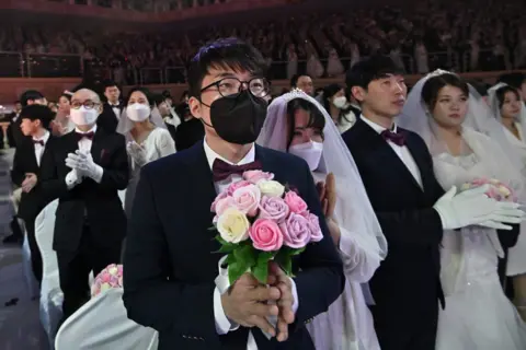 AFP A couple wearing protective face masks attend a mass wedding ceremony organised by the Unification Church in Gapyeong